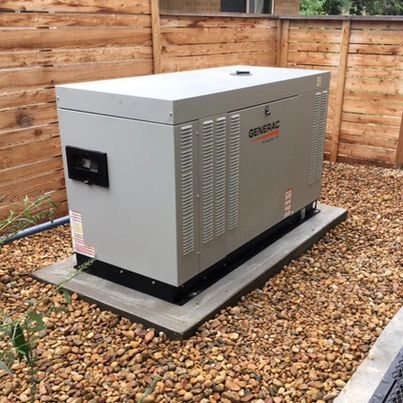 A Generac Generator sits in a gated section of a yard.